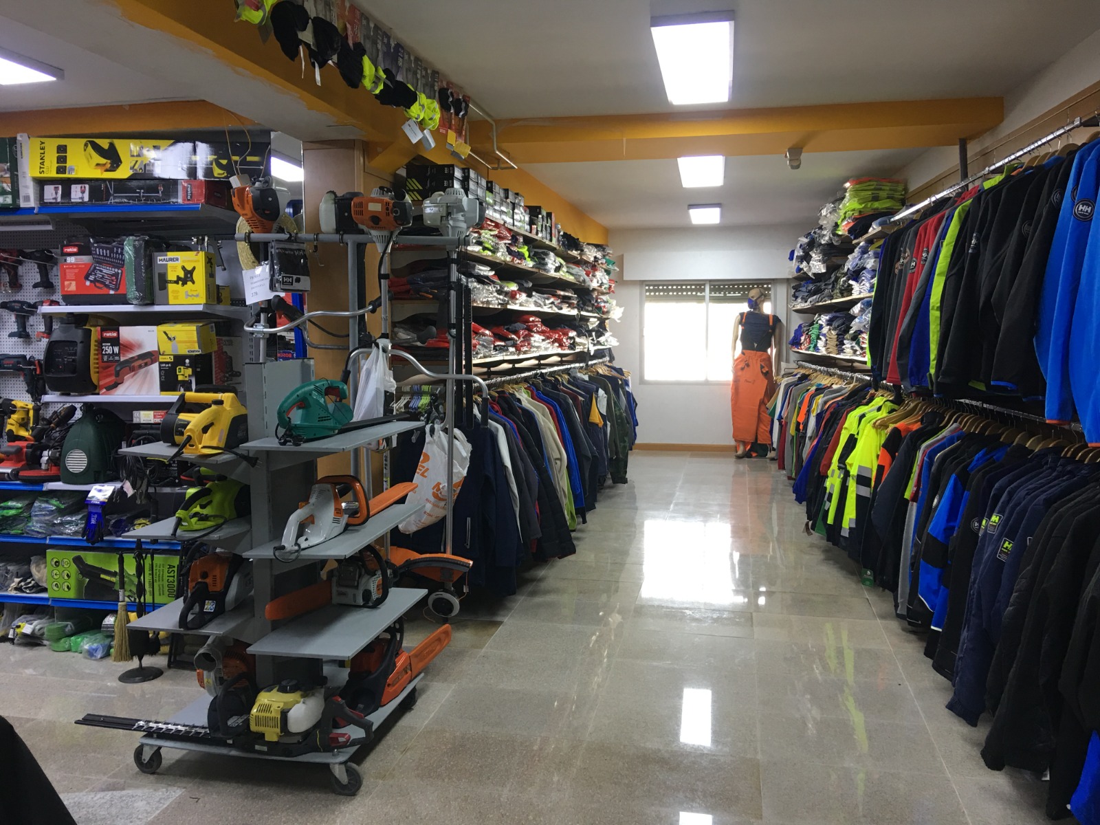 Pasillo de tienda con herramientas y ropa laboral